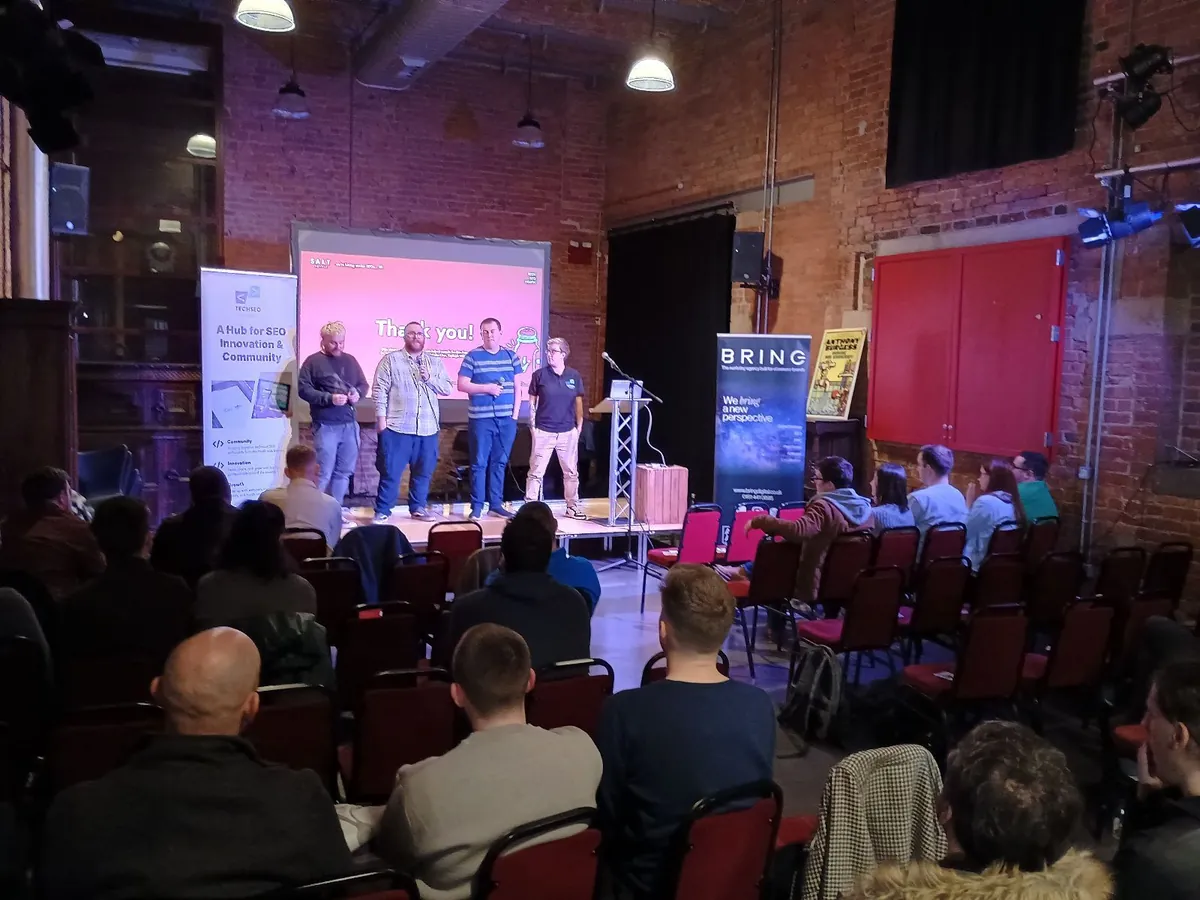 A panel of TSN speakers on stage with the audience seated below